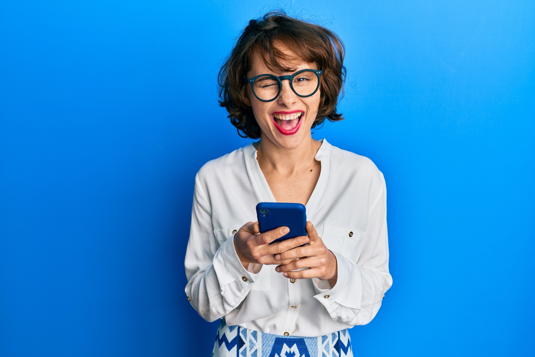 Woman laughing while looking at her phone